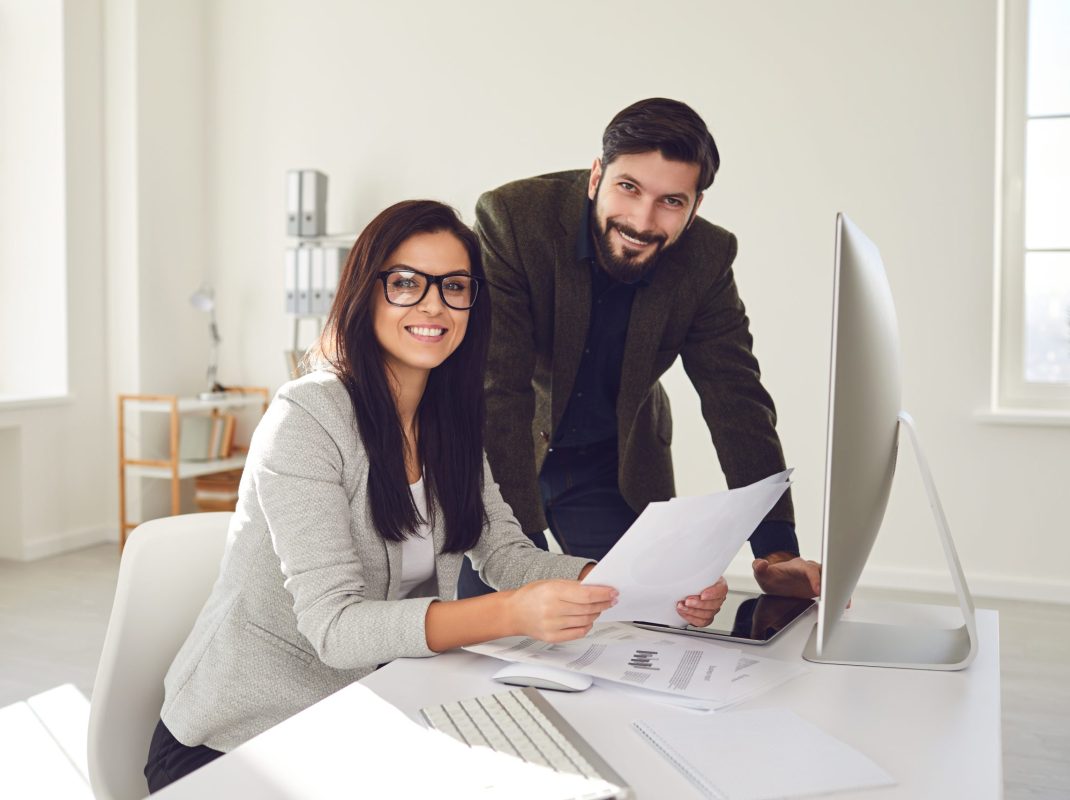 Business people smiling while standing in office. Discussion meeting business people in a white office. The decision to create a startup business.